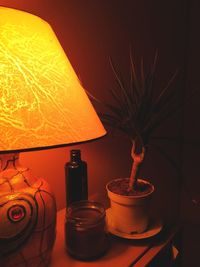 Close-up of illuminated light bulb on table at home