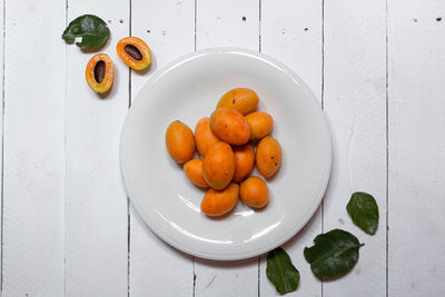 High angle view of orange fruits in plate on table
