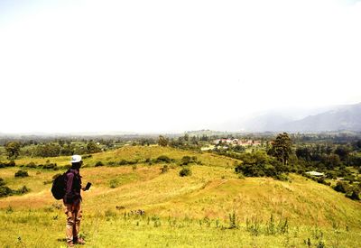 Rear view full length of man standing on landscape against sky