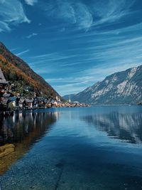 Scenic view of sea by mountains against sky