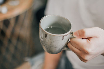 Close-up of hand holding coffee cup