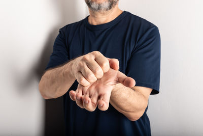 Midsection of man gesturing against white background
