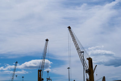 Low angle view of cranes against sky