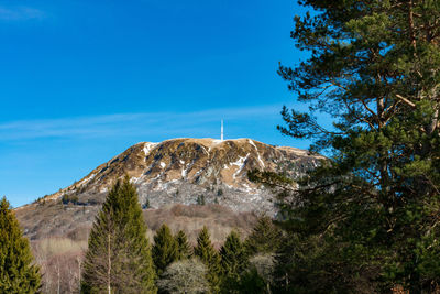 Low angle view of rocky mountains against blue sky