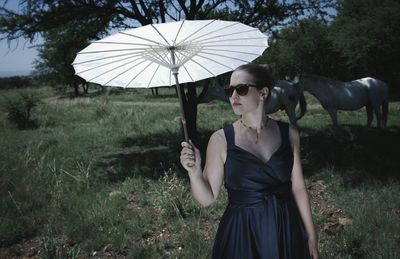 Portrait of woman with sunglasses on umbrella