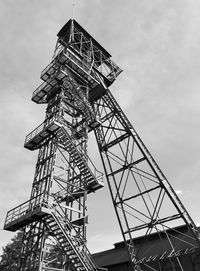 Low angle view of communications tower against sky