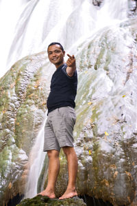 Portrait of smiling young man standing on rock