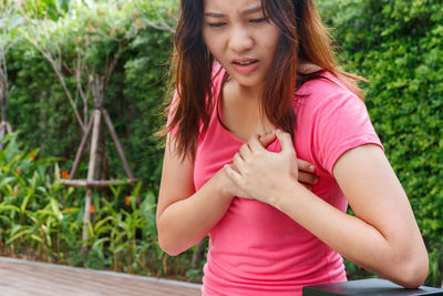 Young woman suffering from chest pain