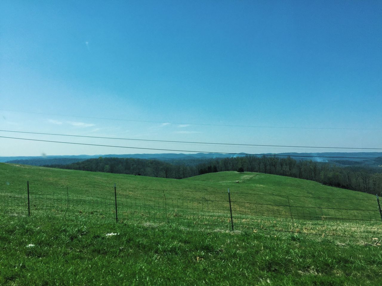 grass, tranquil scene, landscape, blue, tranquility, scenics, green color, growth, field, beauty in nature, nature, plant, countryside, solitude, grassy, remote, hill, green, day, non-urban scene, rural scene, cable, outdoors, sky, no people, grassland, horizon over land, lush foliage, grass area