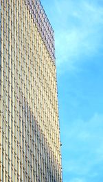 Low angle view of modern building against blue sky