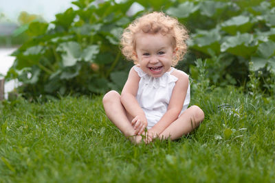 Portrait of smiling boy sitting on grass
