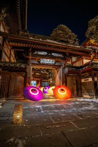 Illuminated lanterns by building at night