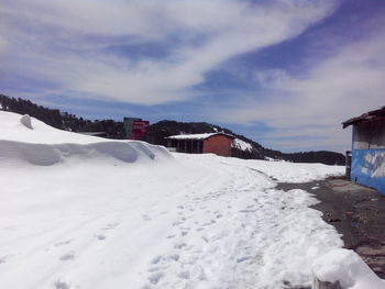 Snow covered landscape against sky