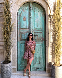 Full length of woman standing against closed door