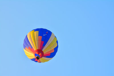 Low angle view of hot air balloon against clear blue sky