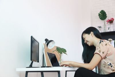 Full length of woman sitting on wall