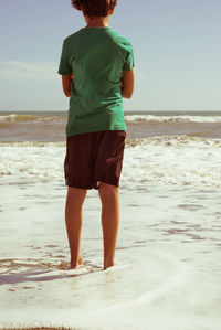 Rear view of boy standing on beach