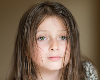 Close-up portrait of cute girl against wall