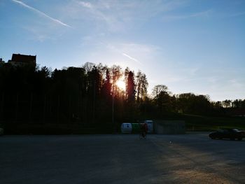 Cars on road against sky during sunset