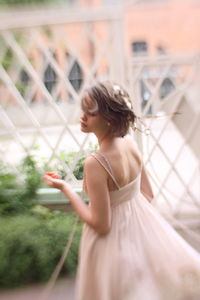 Side view of young woman looking through window
