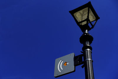 Low angle view of street light against blue sky