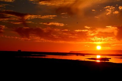 Scenic view of sea against dramatic sky during sunset