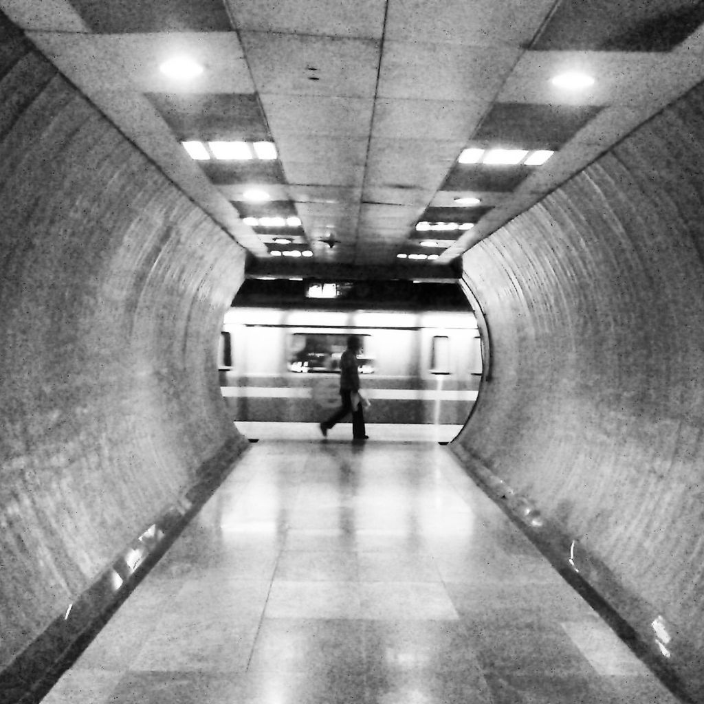 indoors, illuminated, ceiling, the way forward, corridor, architecture, flooring, tiled floor, built structure, subway, lighting equipment, subway station, tunnel, diminishing perspective, men, modern, underground, transportation, walking