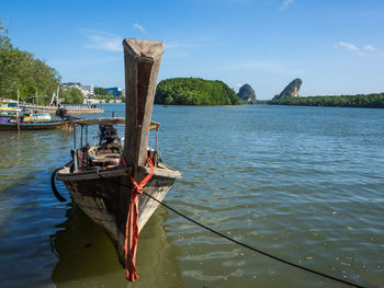 Longtail boat moored on river against sky, krabi, thailand