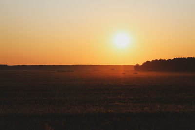 Scenic view of field against clear sky during sunset