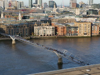 Bridge over river against buildings in city