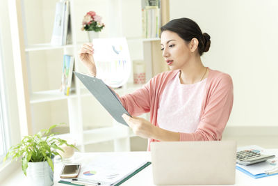 Young woman using smart phone on table