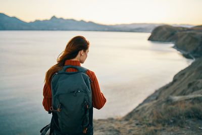 Rear view of woman looking at sea against sky