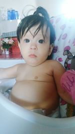 Cute baby girl on bed at home