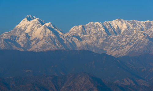 Scenic view of snowcapped mountains against clear sky
