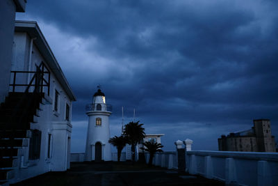 Church amidst buildings against sky at dusk