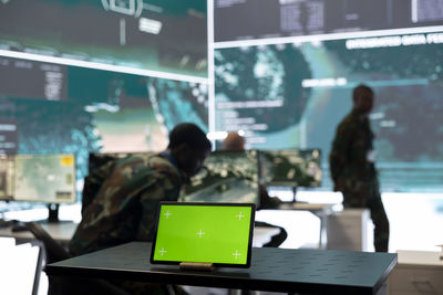 Rear view of man using laptop at office