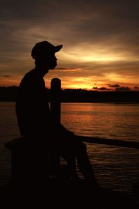 Silhouette man on the beach against the sky at sunset