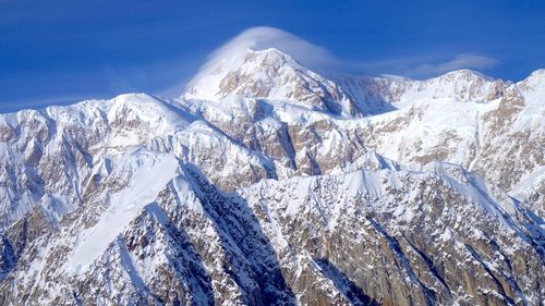 Panoramic view of snowcapped mountains against blue sky