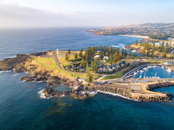 High angle view of city by sea against sky