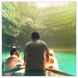 Rear view of couple sitting by sea