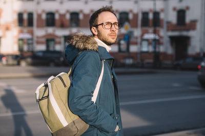 Portrait of young man standing in city