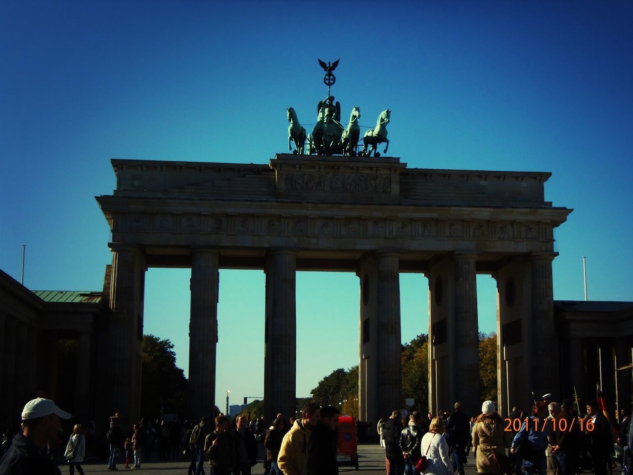 large group of people, famous place, architecture, tourism, built structure, travel destinations, international landmark, statue, clear sky, travel, sculpture, tourist, history, men, person, capital cities, brandenburg gate, monument, architectural column