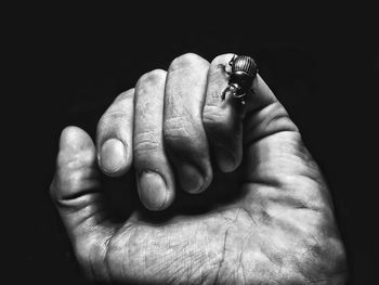 Close-up of human hand against black background