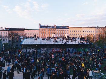 People at town square against sky in city