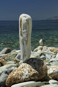 Close-up of rocks in sea against clear sky