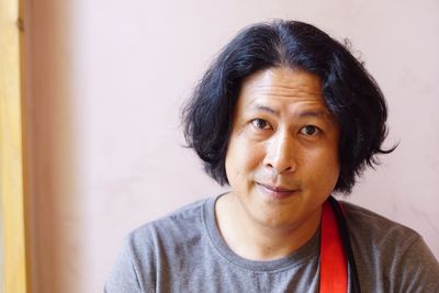 Portrait of smiling man against wall at home