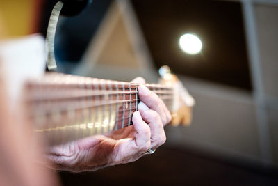 Close-up of senior person playing guitar