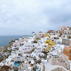 High angle view of townscape by sea against sky