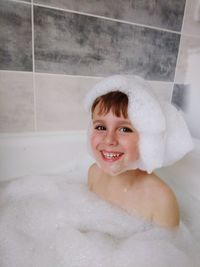 Portrait of smiling boy bathing in bathroom