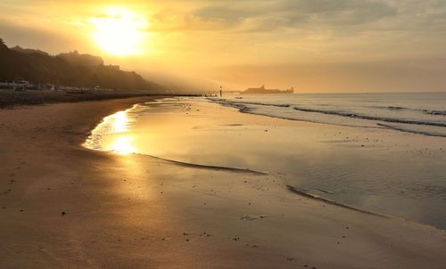 Scenic view of beach against sky during sunset